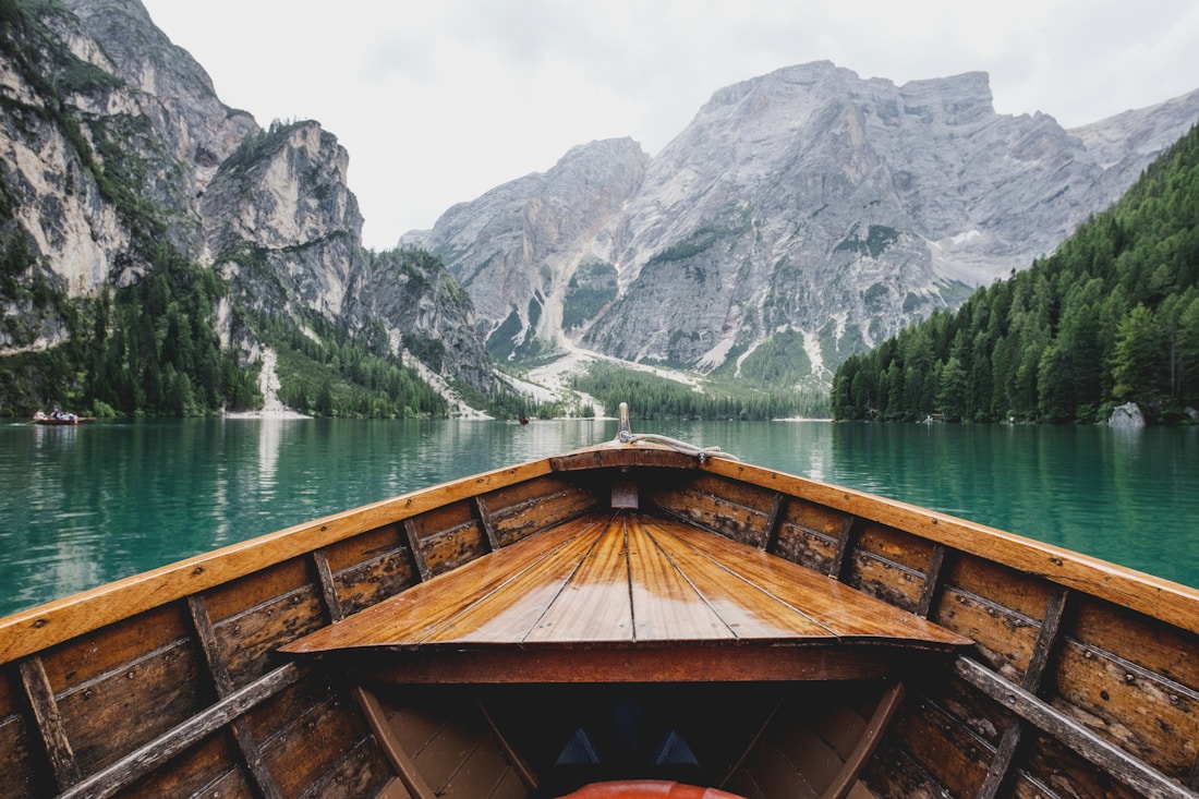 A wooden boat on a still lake beneath the Dolomites